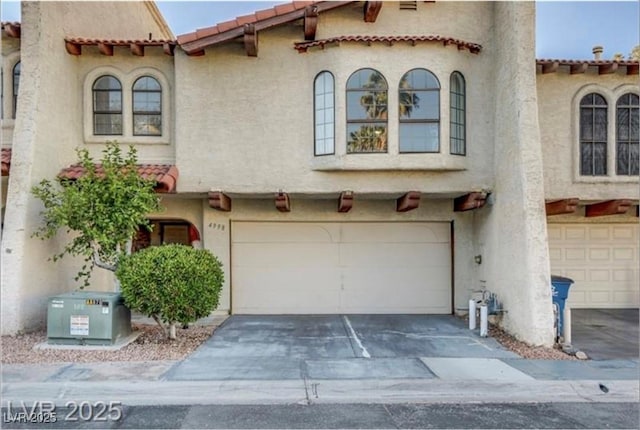4998 Schumann Dr, Las Vegas, NV 89146 - mediterranean / spanish-style home featuring a garage, stucco siding, a tile roof, and driveway