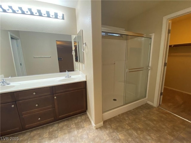 10537 Thor Mountain Ln, Las Vegas, NV 89166 - bathroom featuring a stall shower, double vanity, a spacious closet, and baseboards