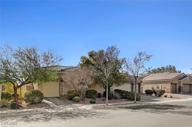 7331 Abundant Harvest Ave, Las Vegas, NV 89131 - obstructed view of property with a garage, concrete driveway, and stucco siding