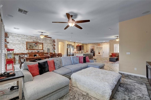 7331 Abundant Harvest Ave, Las Vegas, NV 89131 - living room featuring a ceiling fan, arched walkways, and baseboards