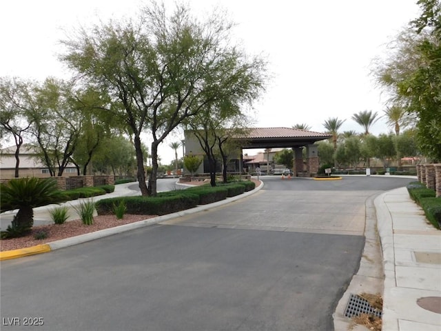 7332 Redhead Dr, North Las Vegas, NV 89084 - view of asphalt street with curbs, sidewalks, and a gated entry