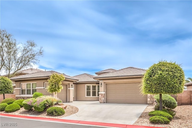 7332 Redhead Dr, North Las Vegas, NV 89084 - prairie-style house featuring a garage, stucco siding, stone siding, and driveway