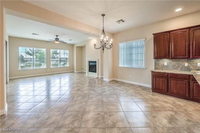 7332 Redhead Dr, North Las Vegas, NV 89084 - kitchen featuring light tile patterned floors, a glass covered fireplace, a ceiling fan, backsplash, and recessed lighting