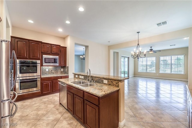 7332 Redhead Dr, North Las Vegas, NV 89084 - kitchen with stainless steel appliances, a chandelier, light tile patterned floors, decorative backsplash, and recessed lighting