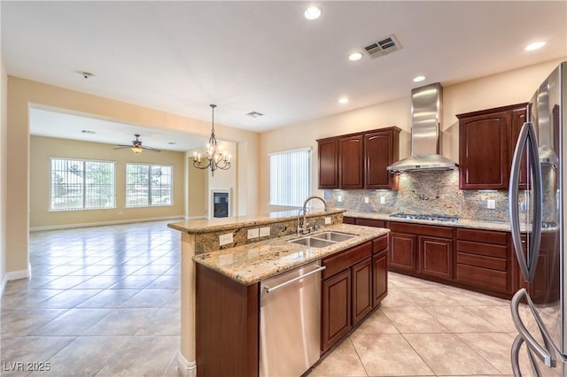 7332 Redhead Dr, North Las Vegas, NV 89084 - kitchen with appliances with stainless steel finishes, wall chimney range hood, light tile patterned flooring, tasteful backsplash, and an island with sink