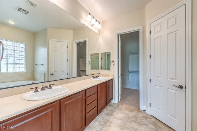 7332 Redhead Dr, North Las Vegas, NV 89084 - bathroom featuring double vanity, tile patterned flooring, a garden tub, and a closet