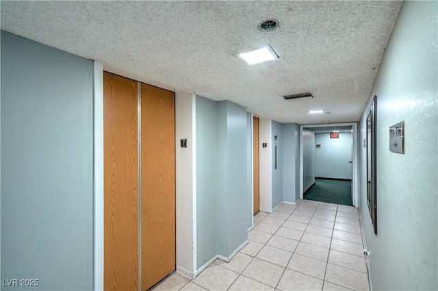 3930 University Center Dr Unit 706, Las Vegas, NV 89119 - corridor with a textured ceiling, light tile patterned flooring, and baseboards