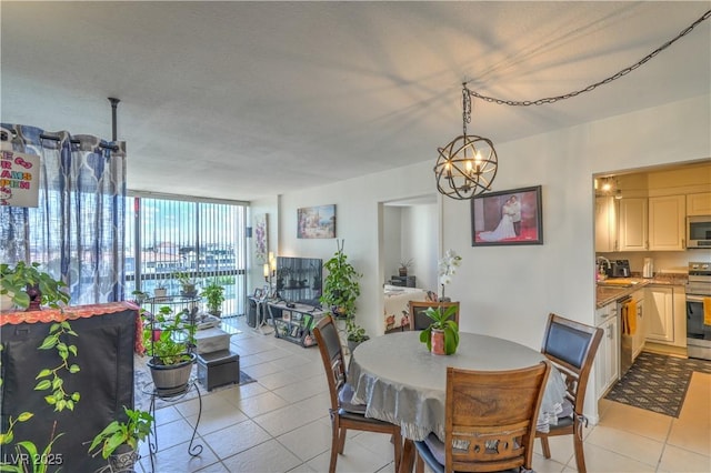 3930 University Center Dr Unit 706, Las Vegas, NV 89119 - dining room with light tile patterned floors, a chandelier, and expansive windows
