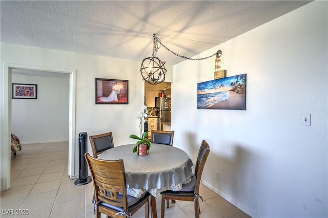3930 University Center Dr Unit 706, Las Vegas, NV 89119 - dining area with light tile patterned floors, a textured ceiling, a chandelier, and baseboards