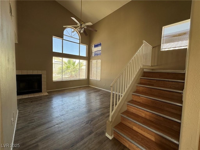 5128 Sandstone Dr, Las Vegas, NV 89142 - stairway with wood finished floors, high vaulted ceiling, ceiling fan, baseboards, and a fireplace