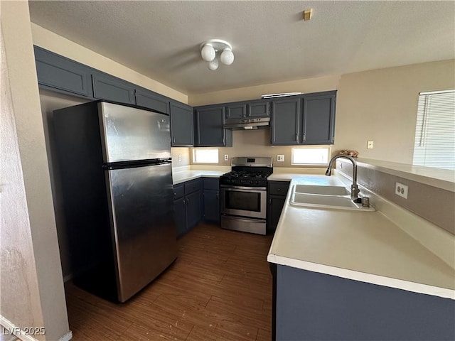 5128 Sandstone Dr, Las Vegas, NV 89142 - kitchen featuring stainless steel appliances, a sink, under cabinet range hood, dark wood finished floors, and light countertops