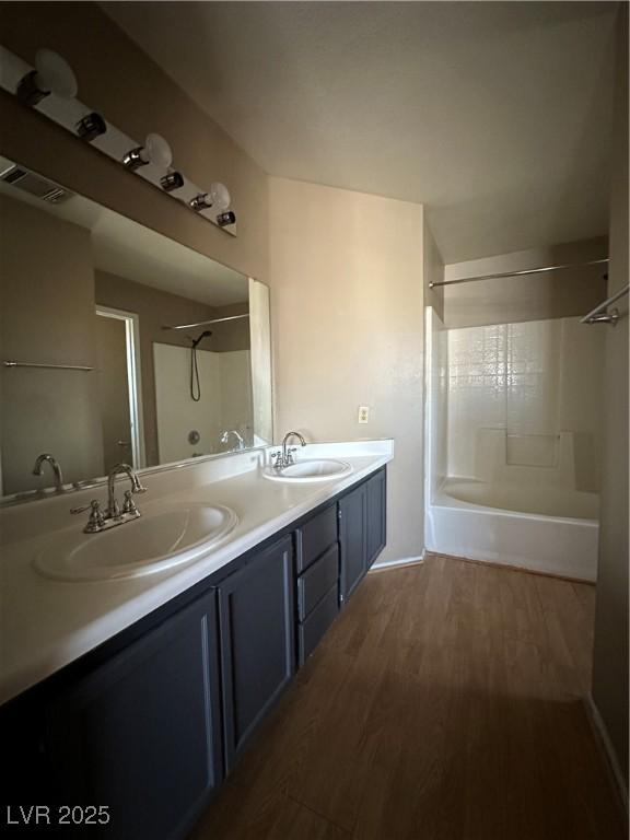5128 Sandstone Dr, Las Vegas, NV 89142 - bathroom with double vanity, wood finished floors, and shower / tub combination