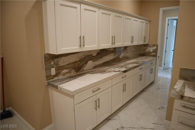 197 E Shelbourne Ave, Las Vegas, NV 89123 - kitchen with light marble finish floors, decorative backsplash, white cabinetry, and baseboards
