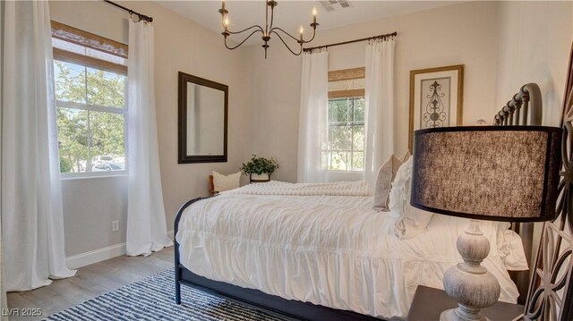 1869 Bronze Patina St, Henderson, NV 89044 - bedroom featuring a chandelier, wood finished floors, and baseboards