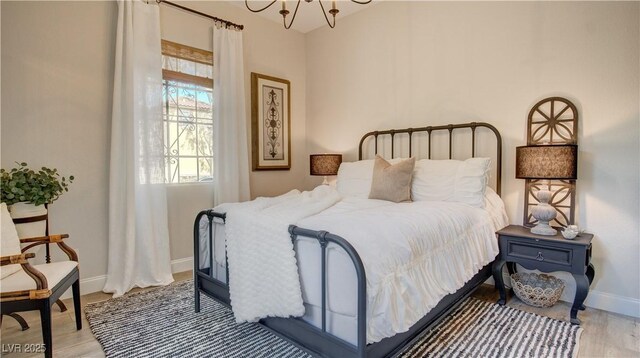 1869 Bronze Patina St, Henderson, NV 89044 - bedroom featuring baseboards, light wood-style floors, and a chandelier