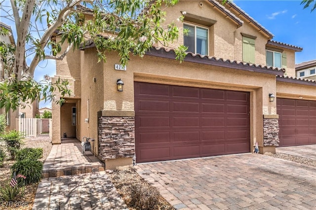 4212 Juanita May Ave, North Las Vegas, NV 89032 - view of front of house with stone siding, stucco siding, an attached garage, and decorative driveway