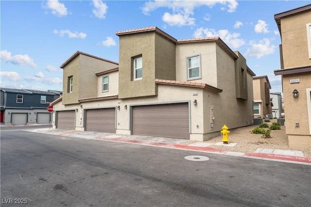 9929 Bumblebee Hills St, Las Vegas, NV 89141 - multi unit property featuring a garage, a tiled roof, stucco siding, and a residential view