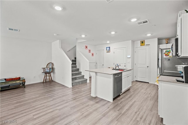 9929 Bumblebee Hills St, Las Vegas, NV 89141 - kitchen featuring stainless steel dishwasher, a sink, white cabinets, an island with sink, and light wood-style flooring