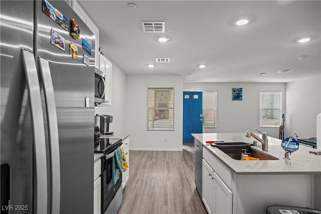 9929 Bumblebee Hills St, Las Vegas, NV 89141 - kitchen with appliances with stainless steel finishes, a sink, light wood-type flooring, baseboards, and white cabinets
