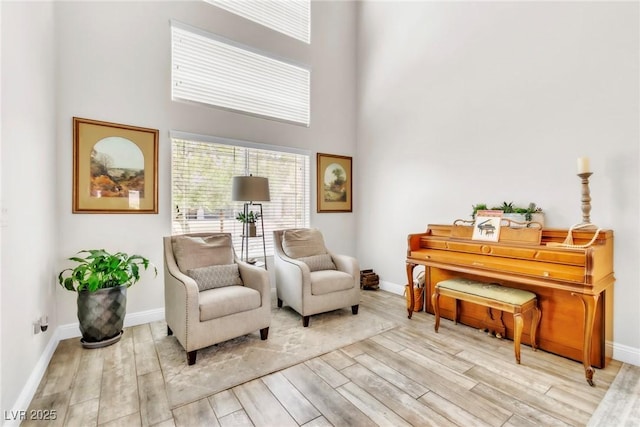 10420 Loma Portal Ave, Las Vegas, NV 89166 - sitting room featuring a towering ceiling, wood finished floors, and baseboards