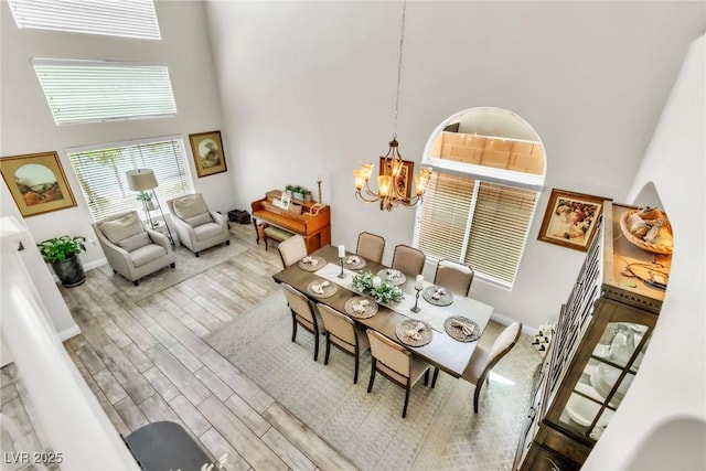 10420 Loma Portal Ave, Las Vegas, NV 89166 - dining area with a towering ceiling, a chandelier, wood finished floors, and baseboards