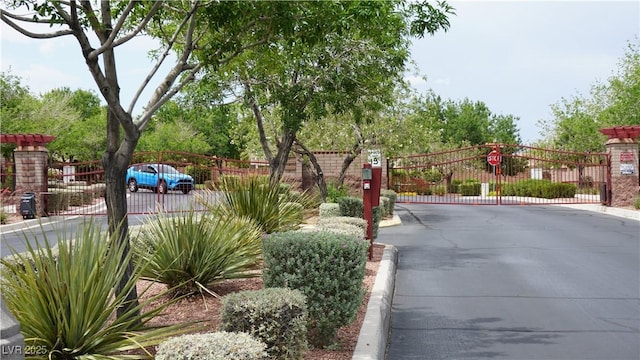 10420 Loma Portal Ave, Las Vegas, NV 89166 - view of asphalt road featuring a gate, a gated entry, and curbs