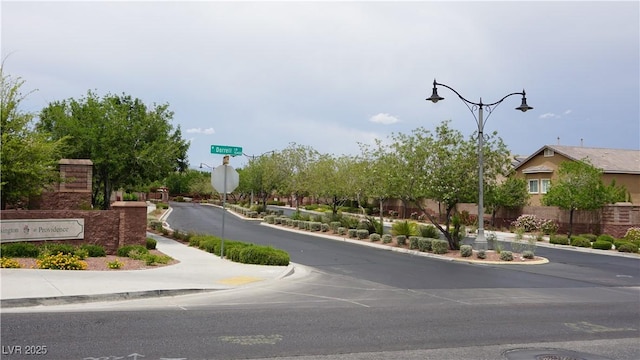 10420 Loma Portal Ave, Las Vegas, NV 89166 - view of asphalt street featuring sidewalks, traffic signs, curbs, and street lighting