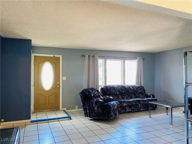 3766 Colonial Dr, Las Vegas, NV 89121 - living room featuring a textured ceiling, light tile patterned floors, and baseboards
