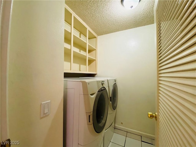 3766 Colonial Dr, Las Vegas, NV 89121 - laundry room with washer and clothes dryer, light tile patterned flooring, and a textured ceiling