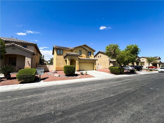 3412 Catherine Mermet Ave, North Las Vegas, NV 89081 - view of front facade with stucco siding, an attached garage, roof mounted solar panels, and concrete driveway