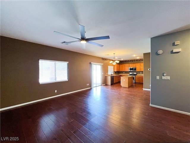 3412 Catherine Mermet Ave, North Las Vegas, NV 89081 - unfurnished living room with a chandelier, ceiling fan, baseboards, and dark wood finished floors