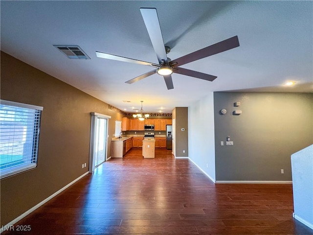 3412 Catherine Mermet Ave, North Las Vegas, NV 89081 - unfurnished living room featuring dark wood-style flooring, a ceiling fan, baseboards, and a chandelier