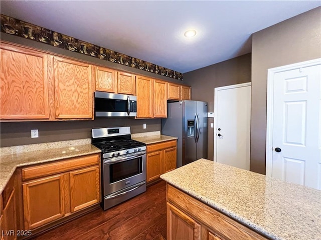 3412 Catherine Mermet Ave, North Las Vegas, NV 89081 - kitchen featuring stainless steel appliances, dark wood-style floors, light stone countertops, and brown cabinets
