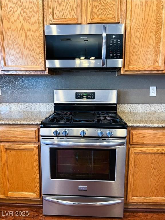 3412 Catherine Mermet Ave, North Las Vegas, NV 89081 - kitchen featuring appliances with stainless steel finishes, wood finished floors, and light stone countertops