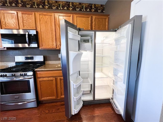 3412 Catherine Mermet Ave, North Las Vegas, NV 89081 - kitchen with appliances with stainless steel finishes, brown cabinets, and dark wood finished floors