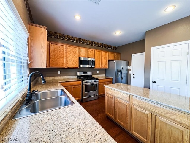 3412 Catherine Mermet Ave, North Las Vegas, NV 89081 - kitchen featuring stainless steel appliances, a sink, dark wood-style flooring, recessed lighting, and brown cabinets