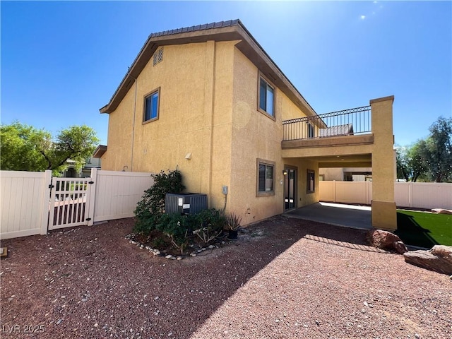 3412 Catherine Mermet Ave, North Las Vegas, NV 89081 - view of side of property with a balcony, central AC unit, a fenced backyard, stucco siding, and a patio area