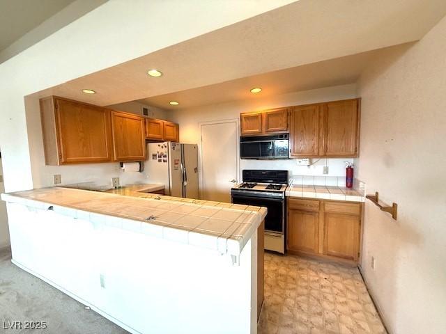 7570 W Flamingo Rd Unit 202, Las Vegas, NV 89147 - kitchen featuring white appliances, tile countertops, brown cabinets, a peninsula, and recessed lighting