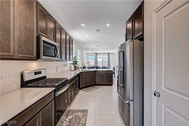 4293 Nopal Serrano Ave, Las Vegas, NV 89141 - kitchen with stainless steel appliances, dark brown cabinets, light tile patterned floors, light countertops, and recessed lighting