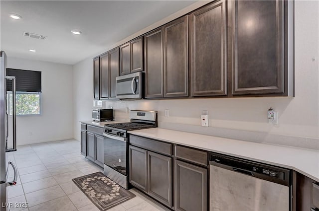 4293 Nopal Serrano Ave, Las Vegas, NV 89141 - kitchen with appliances with stainless steel finishes, dark brown cabinets, light countertops, light tile patterned floors, and recessed lighting