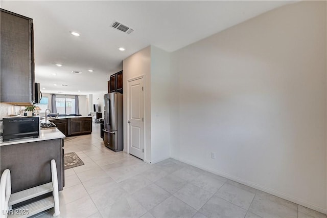 4293 Nopal Serrano Ave, Las Vegas, NV 89141 - kitchen with high end fridge, dark brown cabinetry, light countertops, baseboards, and recessed lighting