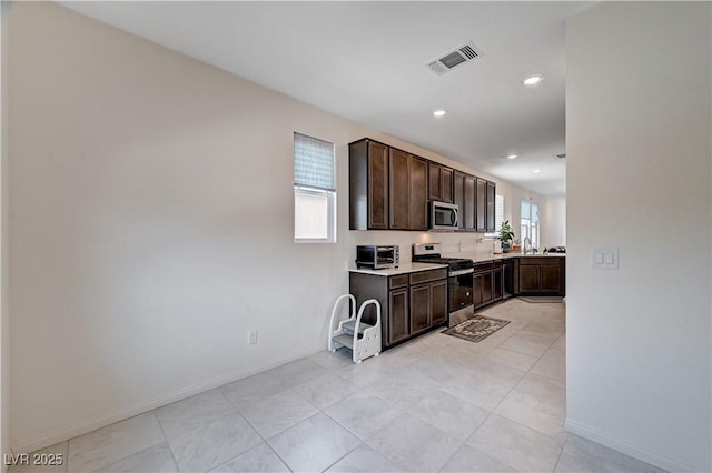 4293 Nopal Serrano Ave, Las Vegas, NV 89141 - kitchen with stainless steel appliances, dark brown cabinets, light countertops, baseboards, and recessed lighting