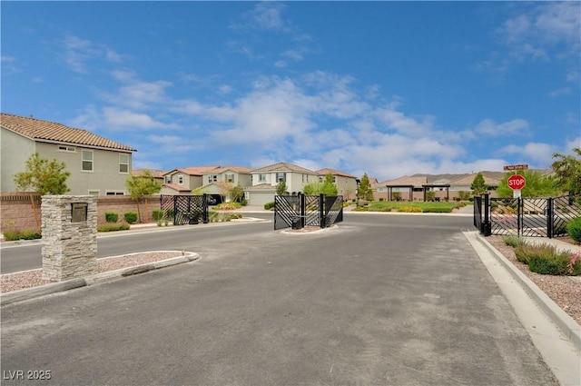 4293 Nopal Serrano Ave, Las Vegas, NV 89141 - view of asphalt street with a residential view, traffic signs, curbs, and a gated entry