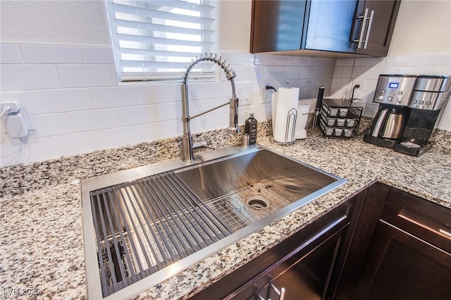 6819 Citron Mist Ct, North Las Vegas, NV 89086 - kitchen view of a sink, tasteful backsplash, light stone counters, and dark brown cabinets