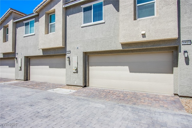 6819 Citron Mist Ct, North Las Vegas, NV 89086 - view of front of property featuring a garage, stucco siding, and decorative driveway