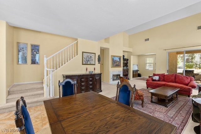 2033 Summer Spruce Pl Unit 102, Las Vegas, NV 89134 - dining room featuring stairs, light carpet, high vaulted ceiling, and baseboards