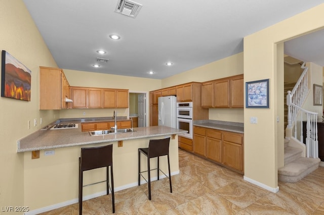 2033 Summer Spruce Pl Unit 102, Las Vegas, NV 89134 - kitchen featuring a sink, a peninsula, white appliances, a kitchen bar, and recessed lighting
