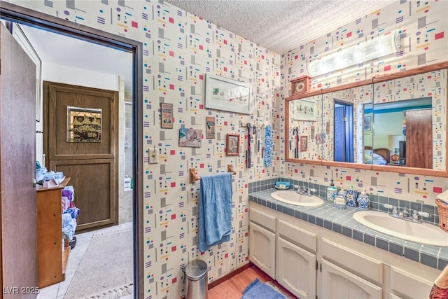2045 S Tenaya Way, Las Vegas, NV 89117 - full bath with double vanity, wallpapered walls, a textured ceiling, and wood finished floors
