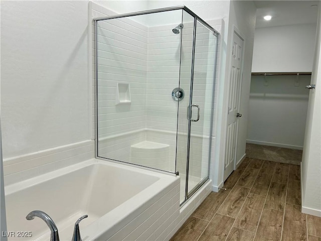 965 Nevada State Dr Unit 39102, Henderson, NV 89002 - bathroom with a stall shower, wood finished floors, a spacious closet, and a garden tub