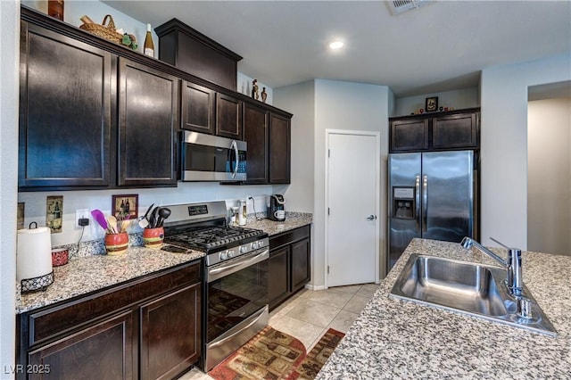5854 Olivine Falls Ave, Las Vegas, NV 89130 - kitchen featuring stainless steel appliances, a sink, dark brown cabinets, light tile patterned floors, and light countertops